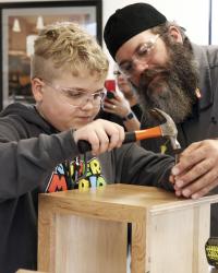 A Dura Supreme employee helps his son learn how a cabinet goes together.